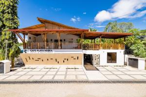 una casa con un pabellón con terraza en Cafe Playa Negra Hotel, en Playa Negra