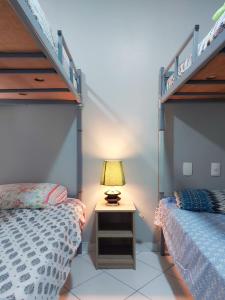 a bedroom with two beds and a lamp on a night stand at Orange - Casa de Hóspedes - modelo Pousada in Rio de Janeiro