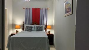 N & A PALACE في خليج مونتيغو: غرفة نوم بسرير مع مصباحين ونوافذ اثنين