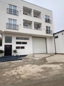 un edificio de apartamentos blanco con 2 puertas de garaje en White Apartments, en Kosovo Polje