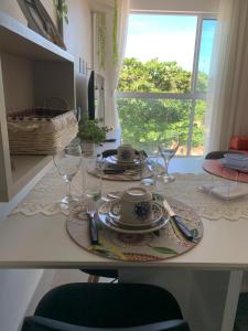 einen Tisch mit einem Teller und Weingläsern darauf in der Unterkunft Lindo e bem localizado in Porto De Galinhas