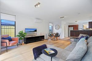 a living room with a couch and a table at Coastal Cove Huskisson in Huskisson