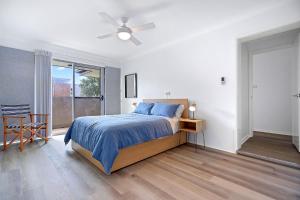 a bedroom with a bed and a ceiling fan at Coastal Cove Huskisson in Huskisson