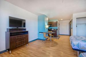 1 dormitorio con 1 cama, TV y mesa en Studio 6-Port Arthur, TX - SE, en Port Arthur