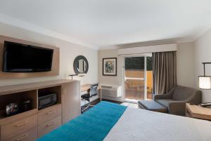 a hotel room with a bed and a flat screen tv at Best Western Woodland Hills in Woodland Hills