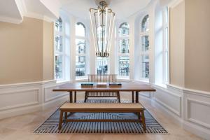 een eetkamer met een tafel en een kroonluchter bij Radisson Blu Kenilworth Hotel, London in Londen