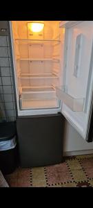an empty refrigerator with its door open in a kitchen at maison de vacances in Halle