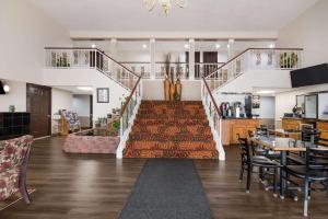 a living room with a staircase and a dining room at SureStay Hotel by Best Western Duncan in Duncan