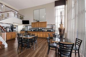 a kitchen and dining room with tables and chairs at SureStay Hotel by Best Western Duncan in Duncan