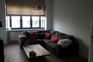 sala de estar con sofá y mesa de centro en charming house with 3 bedrooms & terrace 10 minutes from city centre, en Amberes
