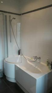 La salle de bains blanche est pourvue d'une douche et d'un lavabo. dans l'établissement charming house with 3 bedrooms & terrace 10 minutes from city centre, à Anvers