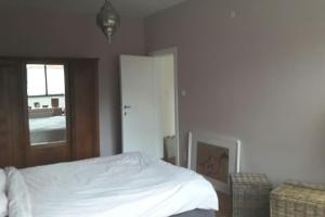 ein Schlafzimmer mit einem weißen Bett und einem Fenster in der Unterkunft charming house with 3 bedrooms & terrace 10 minutes from city centre in Antwerpen