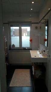 łazienka z umywalką, lustrem i oknem w obiekcie charming house with 3 bedrooms & terrace 10 minutes from city centre w Antwerpii
