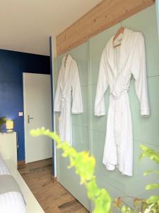 1 dormitorio con albornoces blancos colgados en la pared en Surf ou Golf House a quelques pas de l'océan, en Moliets-et-Maa
