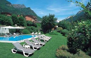 a row of lounge chairs next to a swimming pool at Hotel Aurora in Chiavenna
