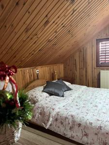 Schlafzimmer mit einem Bett mit Holzdecke in der Unterkunft Brvnara Nenadić in Užice