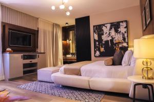 a hotel room with a bed and a tv at Hotel Boutique Corazón Mexicano & Spa in Guanajuato
