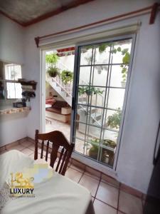a dining room with a table and a large window at Home Sweet Home Guanajuato in Guanajuato