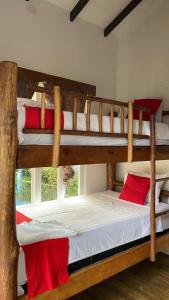 een slaapkamer met 2 stapelbedden met rode kussens bij Hostal Blood Moon in Rio Dulce