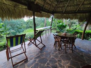 a patio with chairs and a table and a hammock at Eco-Lodge El Porvenir. in Santa Cruz