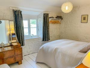 a bedroom with a bed and a window at Greenhills Cottage in Shepton Mallet
