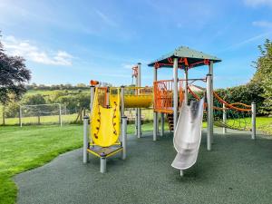 a playground with two slides and a slide at Greenhills Cottage in Shepton Mallet