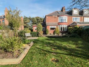 a large brick house with a yard with a green lawn at Clover Leaf in Guisborough
