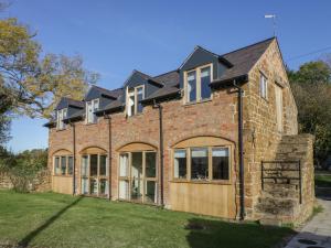 an old brick house with large windows at The Granary in Southam