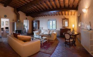 a living room with couches and a table and a tv at Villa Sunbathing in Montelupo Fiorentino
