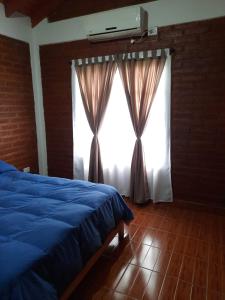 a bedroom with a blue bed and a window at Nuova Costa Cabañas in Los Molles