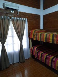 a room with two beds and a window at Nuova Costa Cabañas in Los Molles