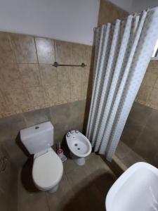 a bathroom with a white toilet and a sink at Nuova Costa Cabañas in Los Molles