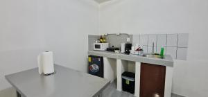 eine Küche mit einer Arbeitsplatte und einer Mikrowelle in der Unterkunft Sleep&Go! Family room - Cabina empresarial en Siquirres in Siquirres