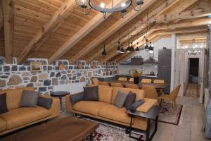 a living room with brown couches and a kitchen at Luxury Villa Saint Sofia in Voskopojë