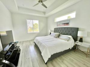 a white bedroom with a bed and a table at New house with canal view in Cape Coral in Cape Coral