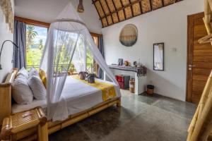 a bedroom with a bed with a mosquito net at Martas Windows in Kuta Lombok