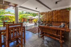 a room with benches and tables and a patio at Martas Windows in Kuta Lombok