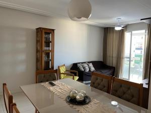 ein Wohnzimmer mit einem Tisch und einem Sofa in der Unterkunft apartamento praia do morro - beira mar in Guarapari