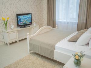 ein Schlafzimmer mit einem Bett und einem TV auf dem Tisch in der Unterkunft Luxury Apartments with Jacuzzi in Sumy