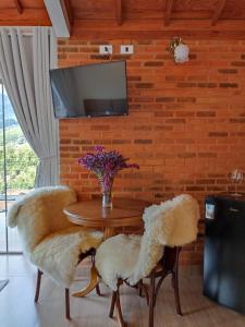 une salle à manger avec une table, deux chaises et une télévision dans l'établissement Valle Piemonte, à Divisa