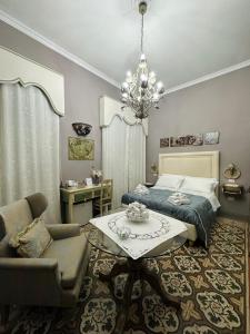 1 dormitorio con cama, mesa y lámpara de araña en Estes, en Crotone
