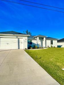 a house with a driveway in front of a yard at New house with canal view in Cape Coral in Cape Coral