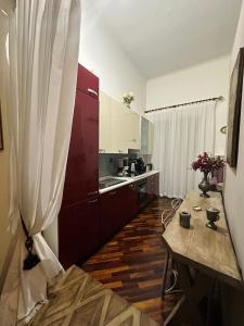 uma cozinha com armários vermelhos e piso em madeira em Estes em Crotone