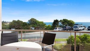 un balcone con tavolo e sedie e un parcheggio di Seacrest Unit 1 Moffat Beach QLD a Caloundra