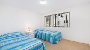 una camera da letto con due letti e una finestra di Seacrest Unit 1 Moffat Beach QLD a Caloundra Altre 4 foto