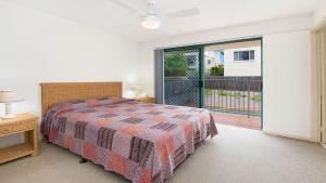 una camera da letto con un letto e una porta scorrevole in vetro di Seacrest Unit 1 Moffat Beach QLD a Caloundra