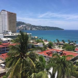 a city with palm trees in front of the ocean at Departamento Familiar en Acapulco con Hermosa Vista! in Acapulco