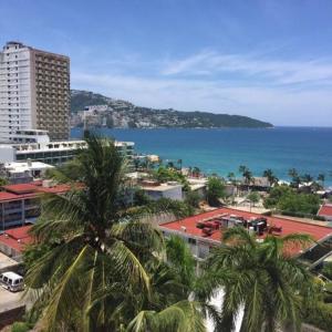 a city with palm trees in front of the ocean at Departamento Familiar en Acapulco con Hermosa Vista! in Acapulco