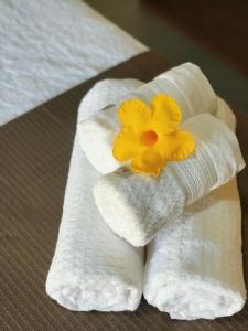 a towel with a yellow flower on top of it at Pousada Villa Kai in São Miguel dos Milagres