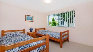 una camera da letto con due letti e una finestra di Seacrest Unit 3 Moffat Beach QLD a Caloundra